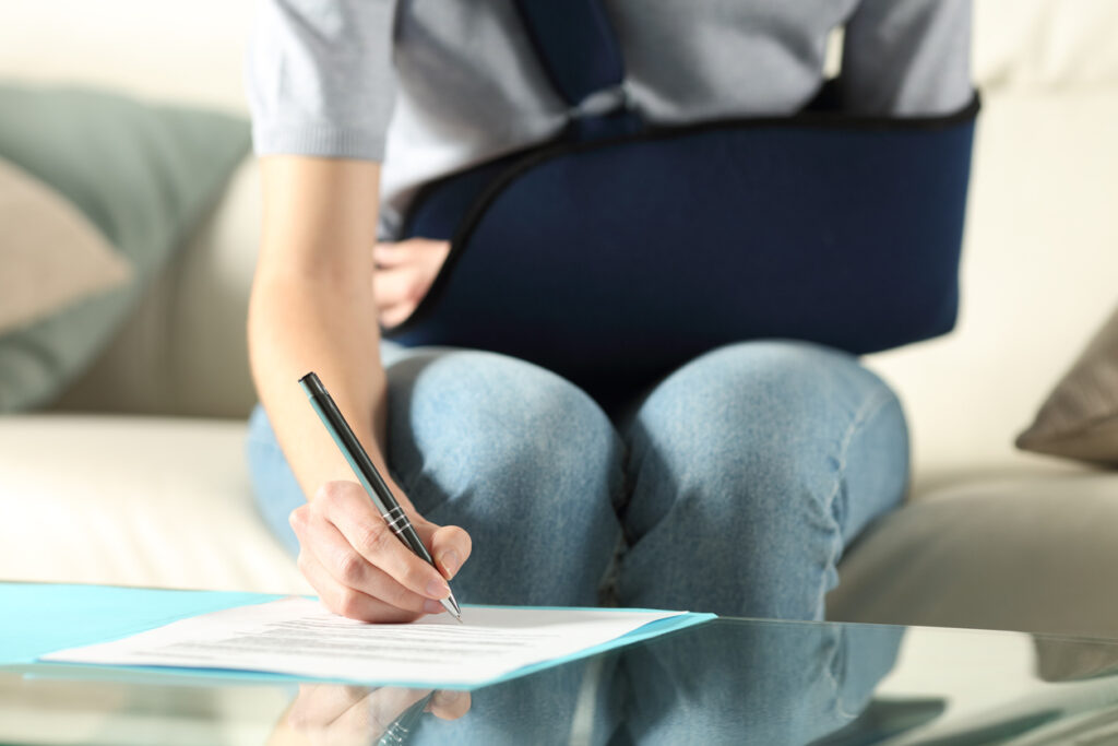 An injured woman signing on settlement paper