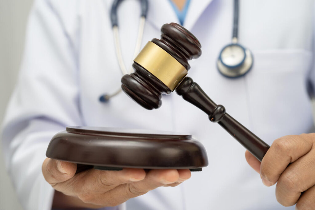 A doctor holding lawyer gavel, representing an Independent Medical Exam (IME) relevant to Missouri employer interests.