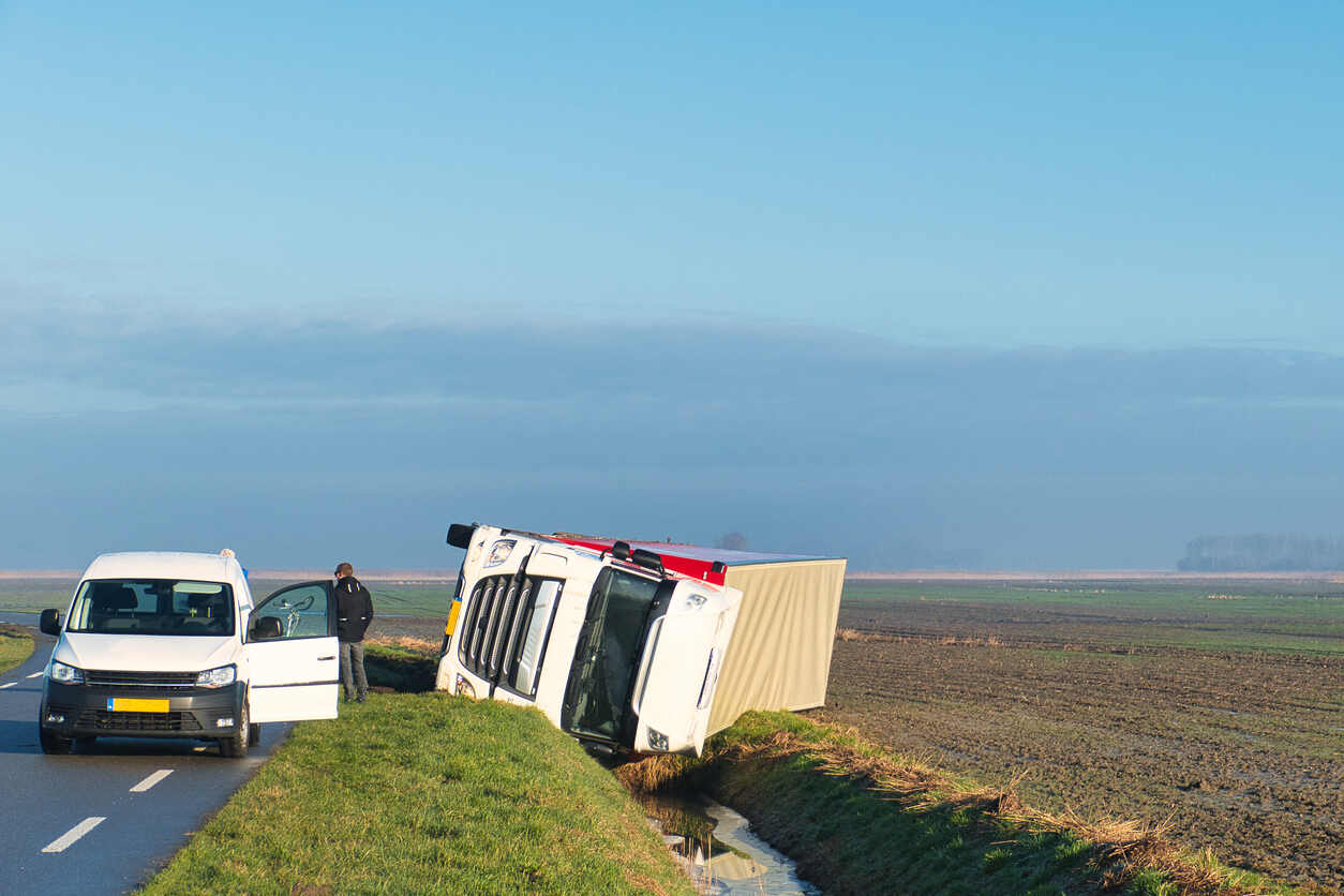 Overturned truck on rural road in St. Louis, highlighting hazards contributing to severe commercial vehicle collisions along trucking routes.